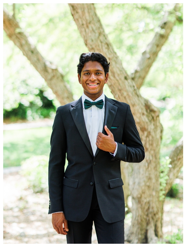 High school senior boy holding tuxedo lapel