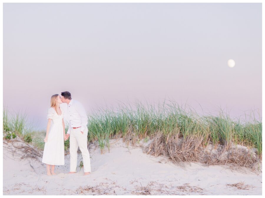 Couple kissing in front of the moon on the beach Dennis Engagement Session Cape Cod