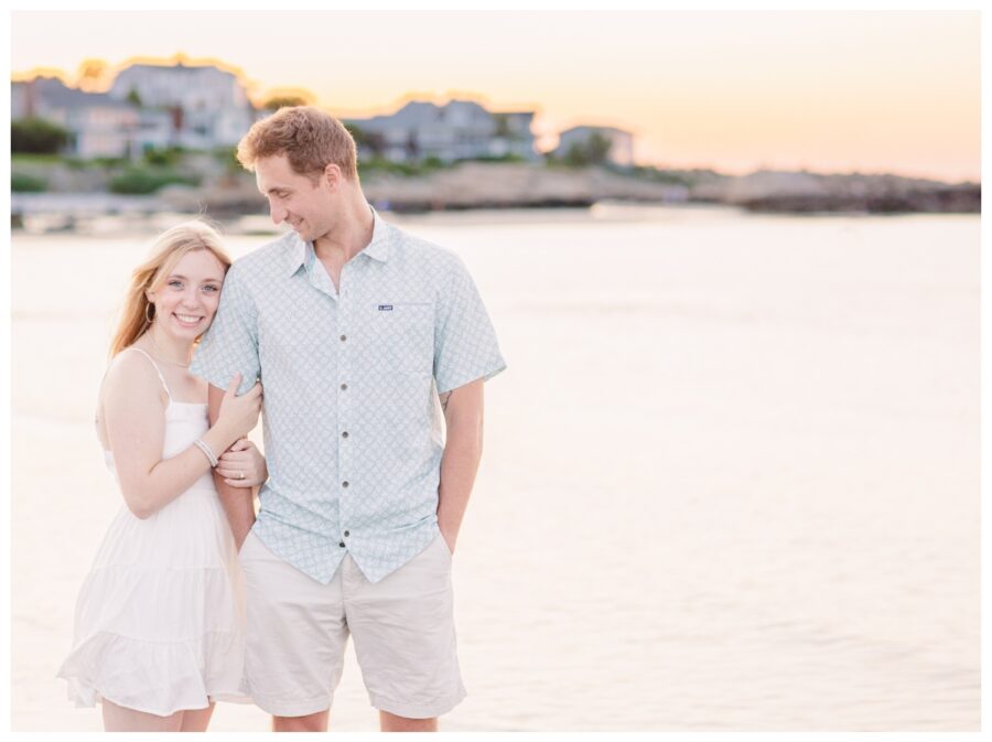 Bride holding on to groom at the ocean at Wingaersheek Beach Engagement session in Gloucester, MA