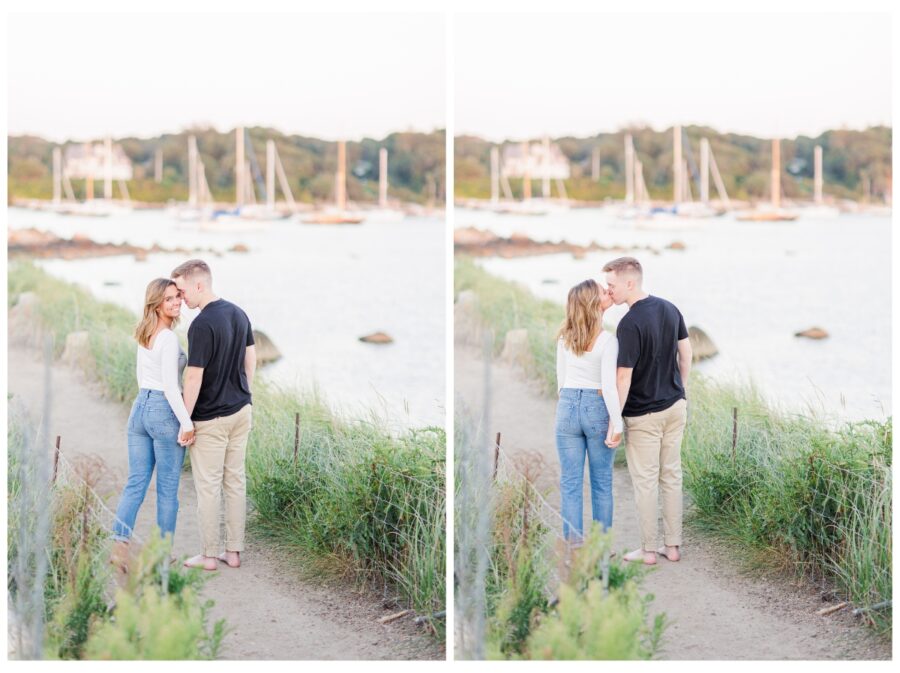A couple walking down a path with boats in the background at The Knob Engagement Session Falmouth, MA Cape Cod