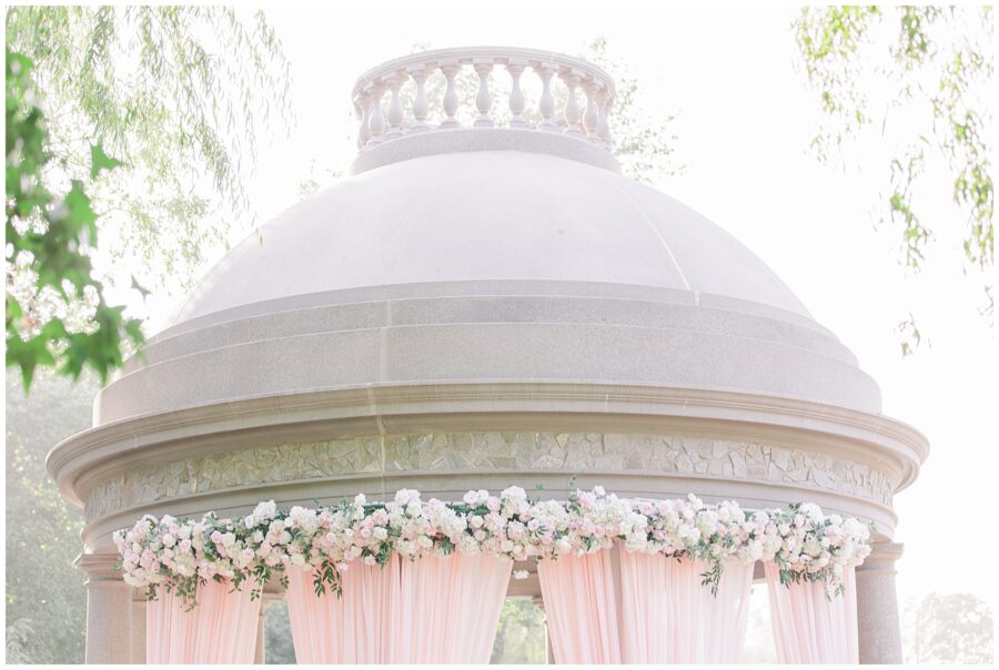 Dome of the tempietto with wedding florals and blush draping at Larz Anderson Park in Brookline, MA