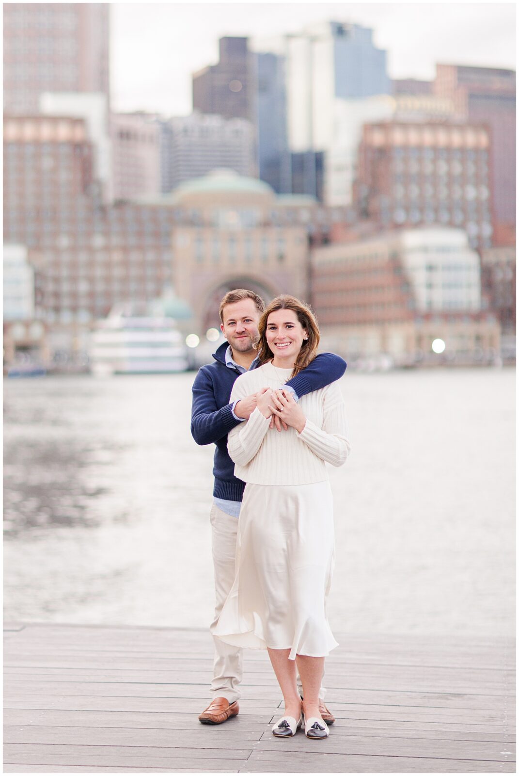 Man holding onto woman during Boston Seaport engagement session.