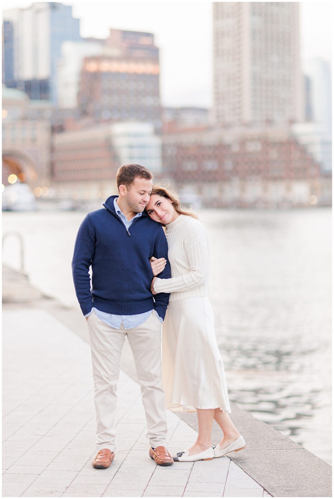 Woman resting her head on man during Boston Seaport engagement session.