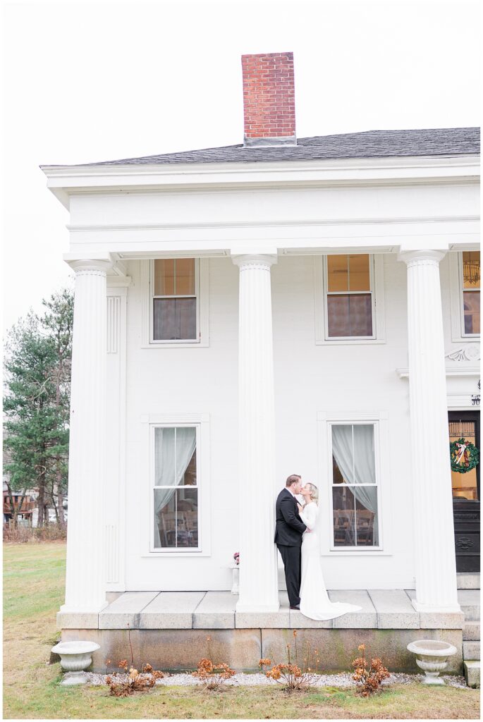 Bride and groom kissing outside of a historical home during their central MA elopement