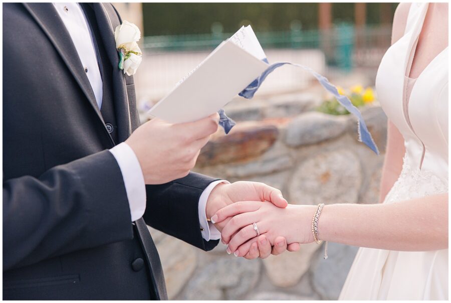 Bride and groom holding hands while exchanging private vows