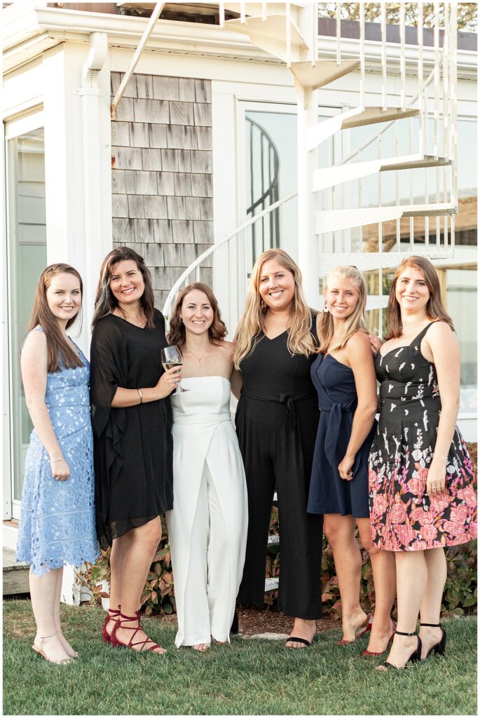 Bride and bridesmaids smiling for a group photo at a Cape Cod rehearsal dinner