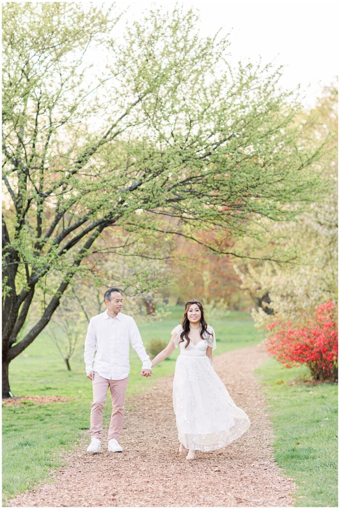 Couple holding hands and walking at Arnold Arboretum representing Boston engagement pictures