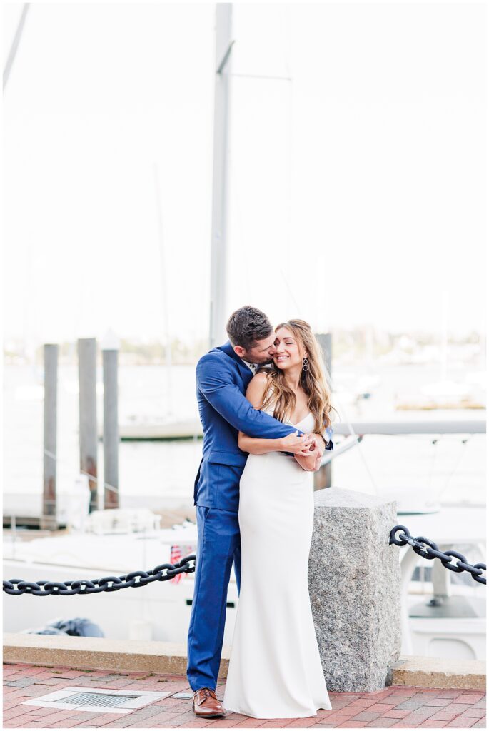 A couple snuggling at Rowe's Wharf representing Boston engagement photos
