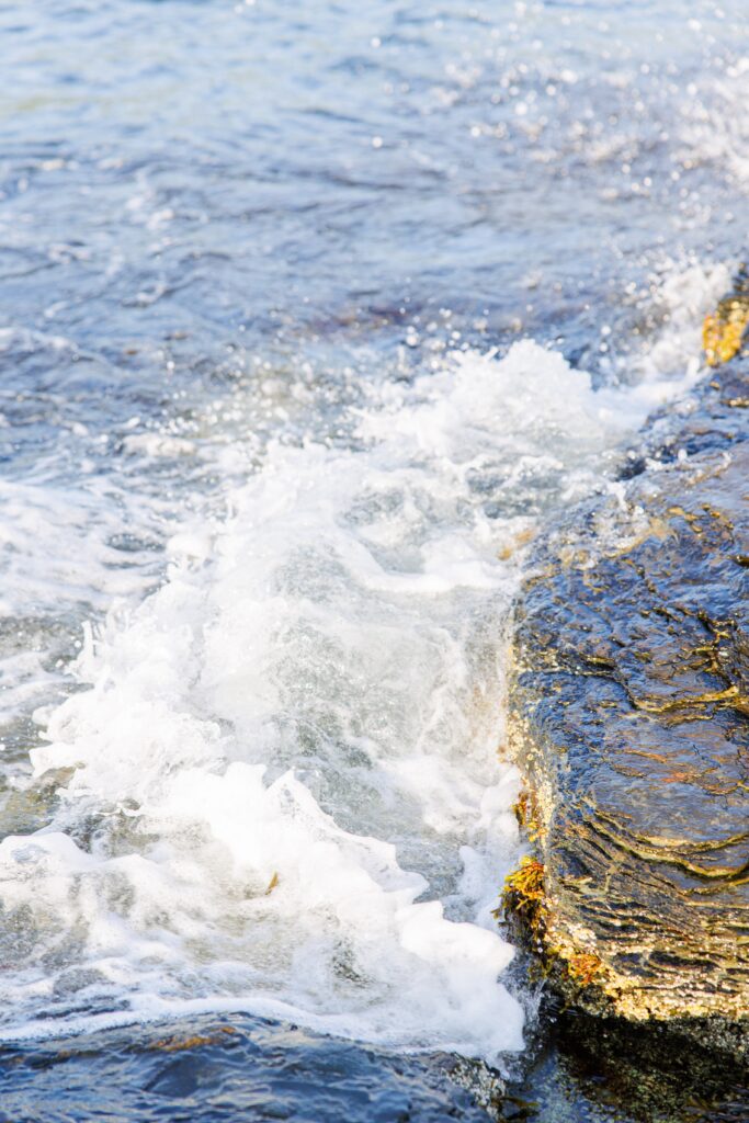 Waves crashing against rocks representing the best Cape Cod wedding venues