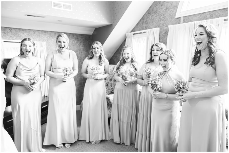 Bridesmaids smiling and reacting to seeing the bride in her dress for the first time during a NH Wedding