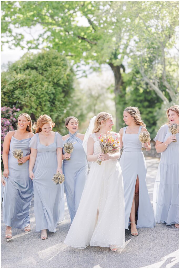 Bride and bridesmaids walking and smiling at each other during a NH wedding