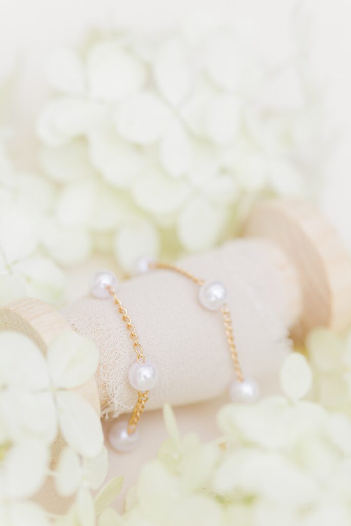 Gold and pearl bracelet on a spool of ribbon representing Boston wedding photography