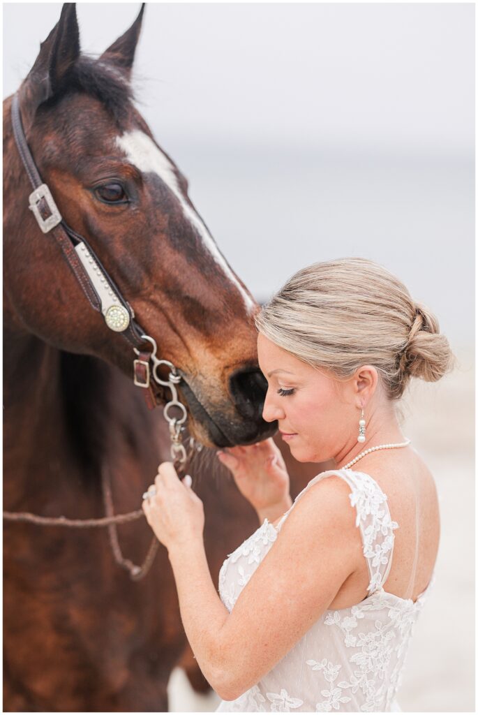 Bride holding her horse's reigns and snuggling with her horse 