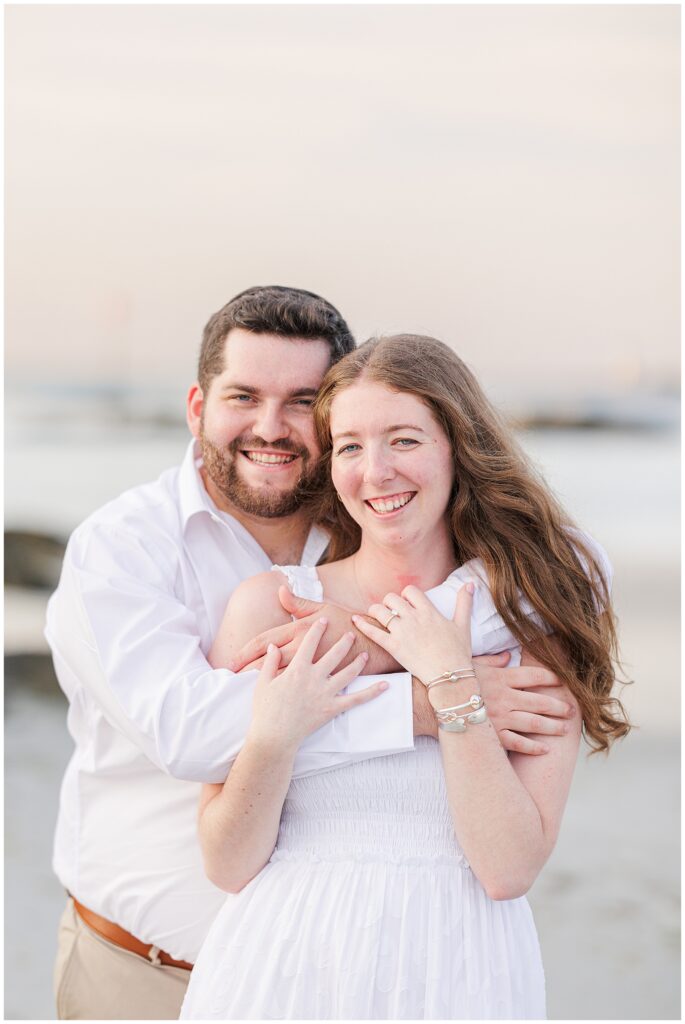 Close up of a man and woman hugging at a Gloucester beach