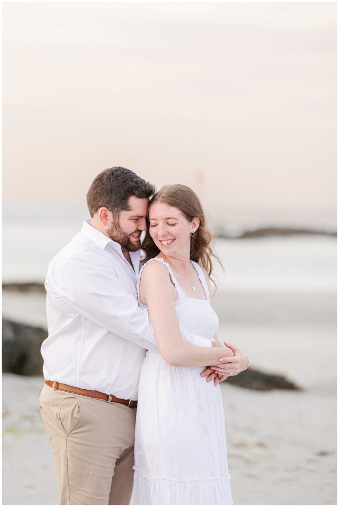 A woman looking back and smiling at a man as they hug at Wingaersheek