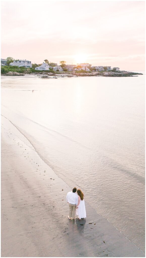 Aerial view of a couple holding hands on Wingaersheek beach watching the sunset