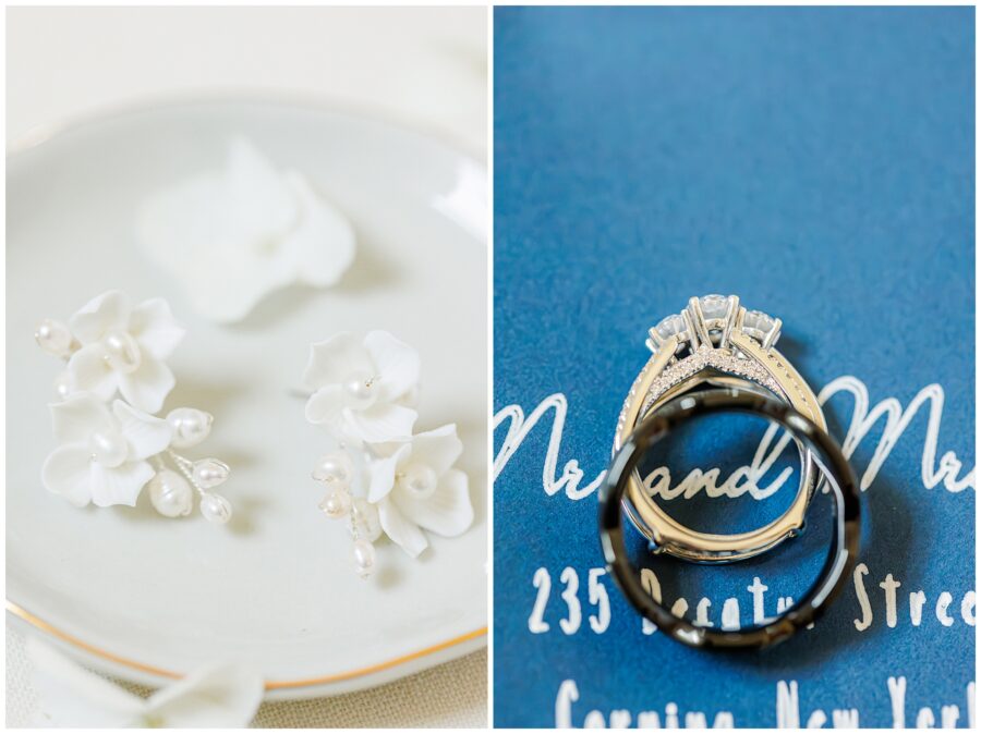 Close-up of white floral earrings and wedding rings. The earrings have small white flowers with pearl centers. The rings are arranged on a blue background with calligraphy.