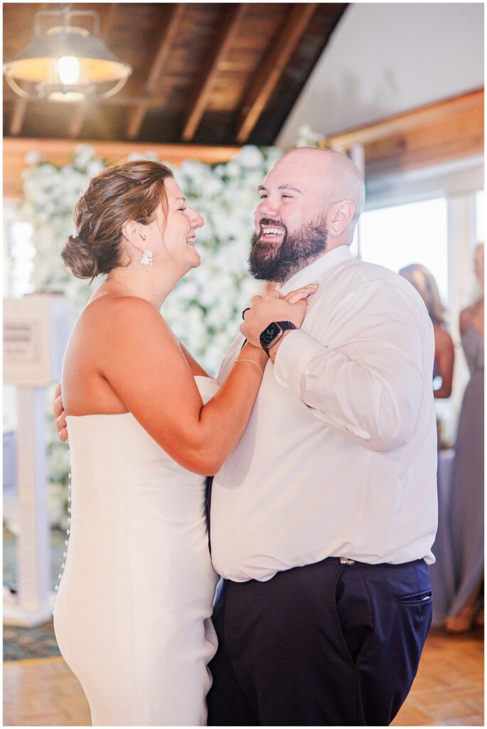 Bride and groom smiling and dancing together during their reception. Location: Lighthouse Inn, Cape Cod.