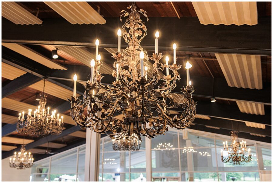 Ornate chandelier with multiple lit candles inside the reception hall.