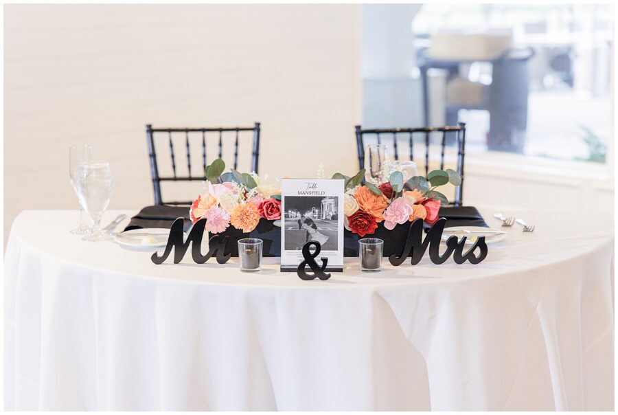 Wedding sweetheart table with a “Mr. & Mrs.” sign and floral centerpiece