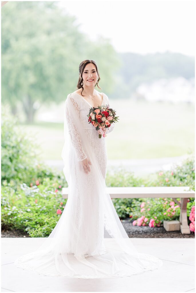 Bride in a lace gown holding a bouquet.