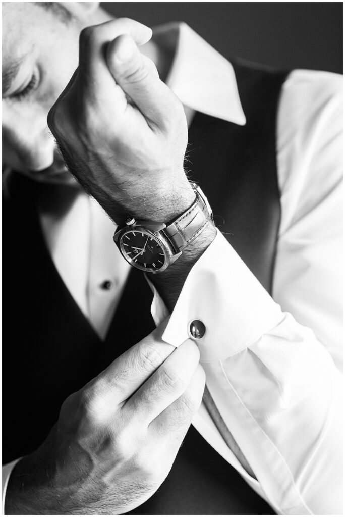 Groom adjusting cufflinks.