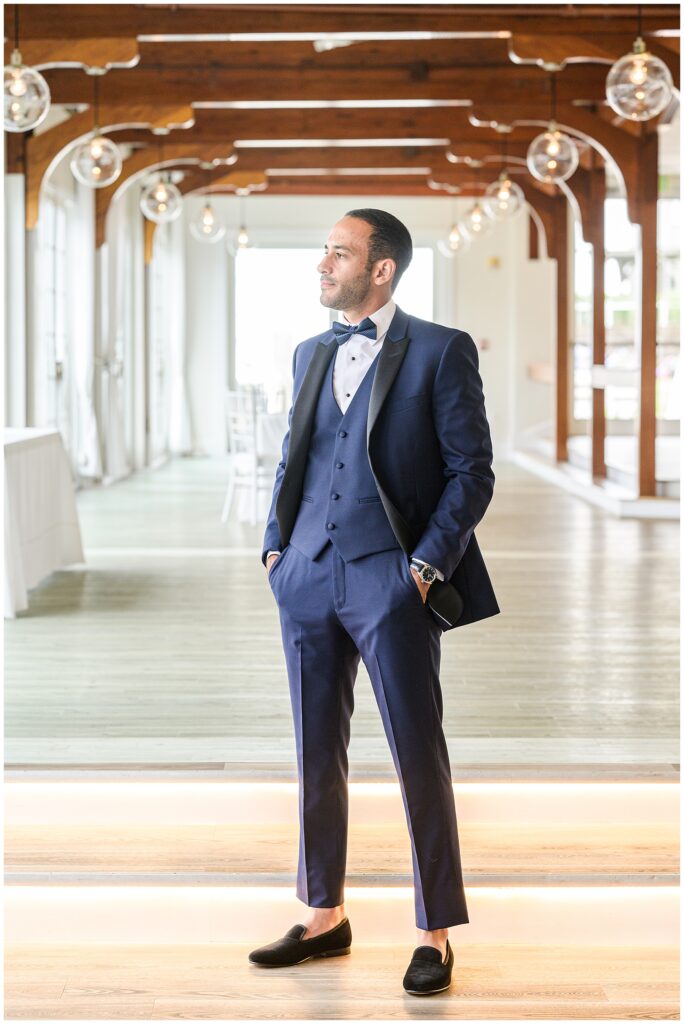 Groom in blue suit posing at Wychmere Beach Club.