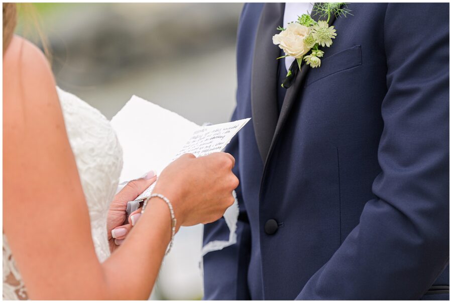 Close-up of bride reading vows to groom.