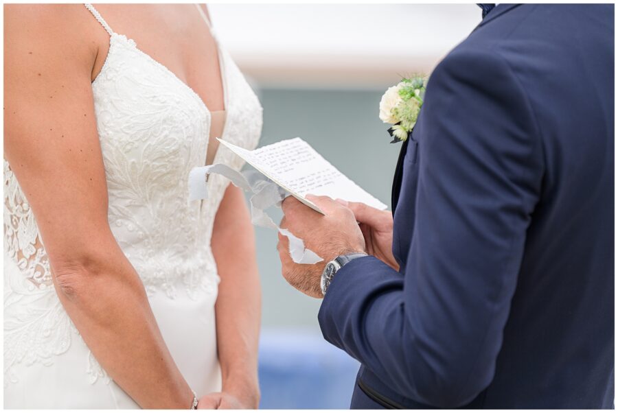 Close-up of groom reading vows to bride.