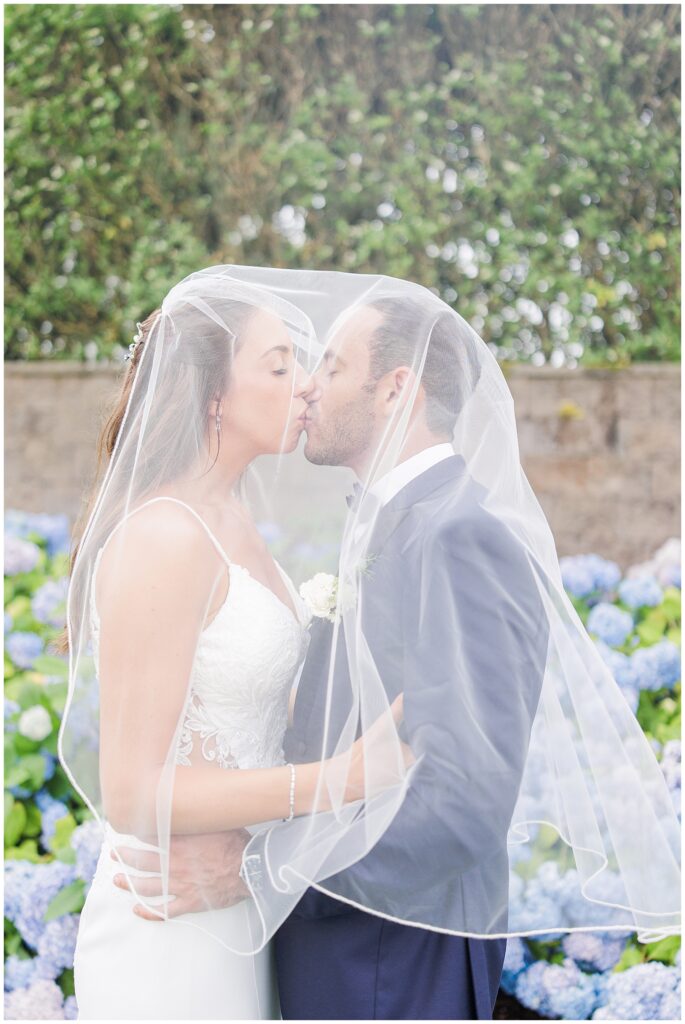 Bride and groom kissing under her veil at the Wychmere Beach Club.