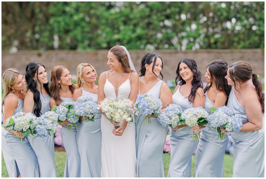 Bride with her bridesmaids holding blue hydrangea bouquets at the Wychmere Beach Club.