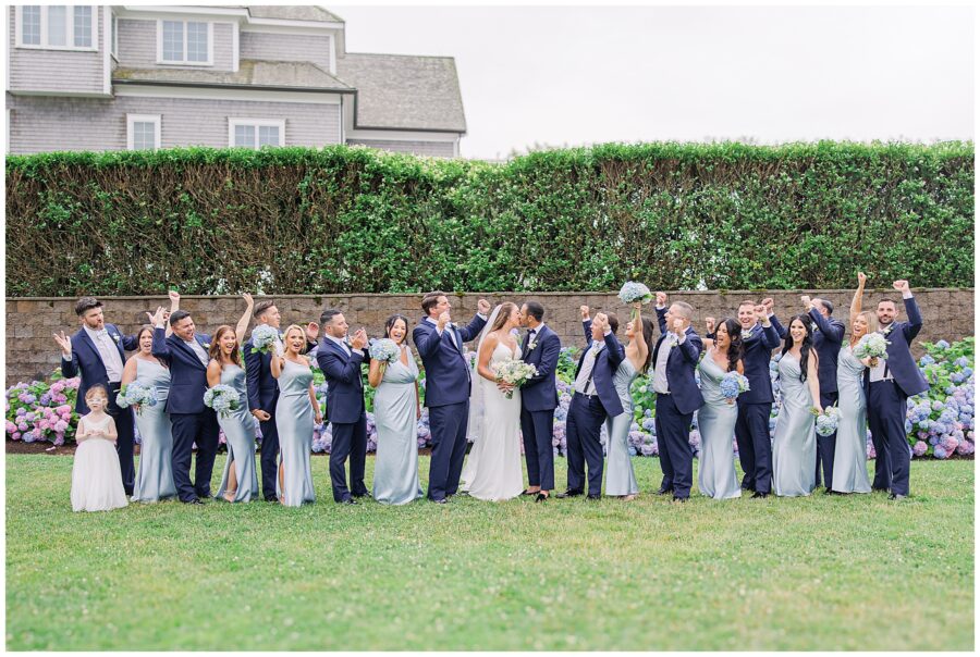 Wedding party cheering as bride and groom kiss at the Wychmere Beach Club.