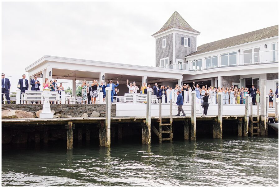 Wedding guests waving from a dock at Wychmere Beach Club.