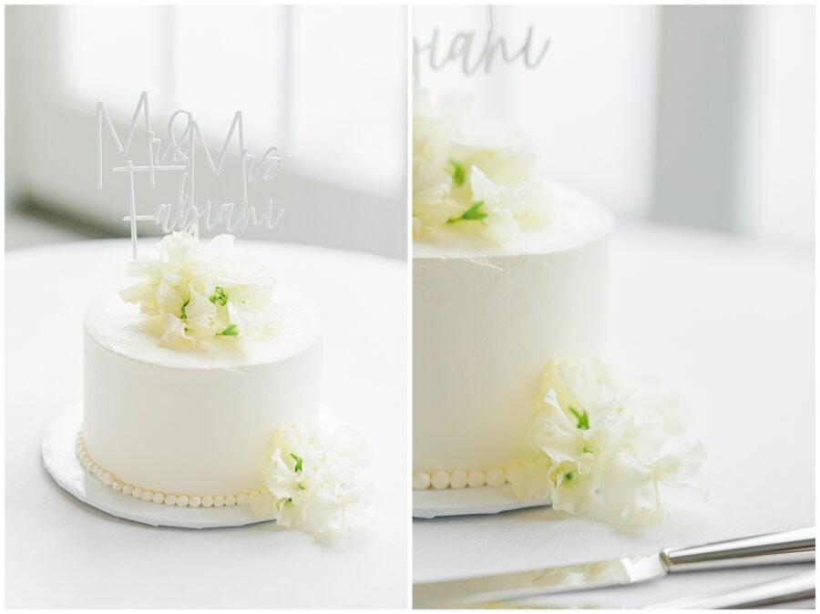 White wedding cake with "Mr & Mrs Fabiani" topper and delicate floral decorations.