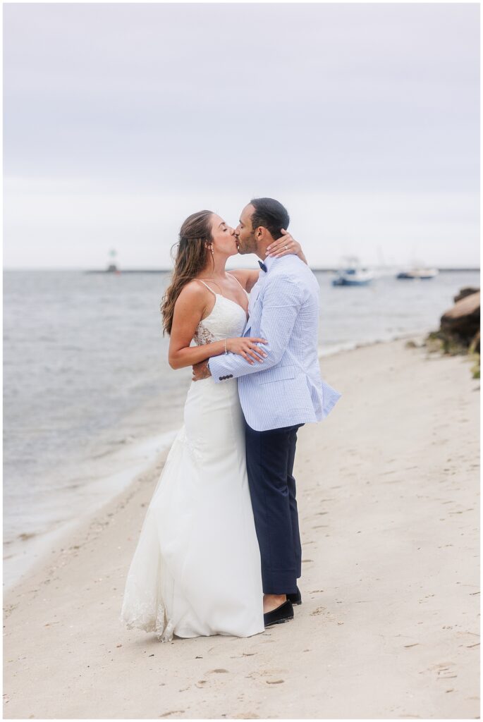 Bride and groom kissing on a beach. Wychmere Beach Club wedding on Cape Cod.