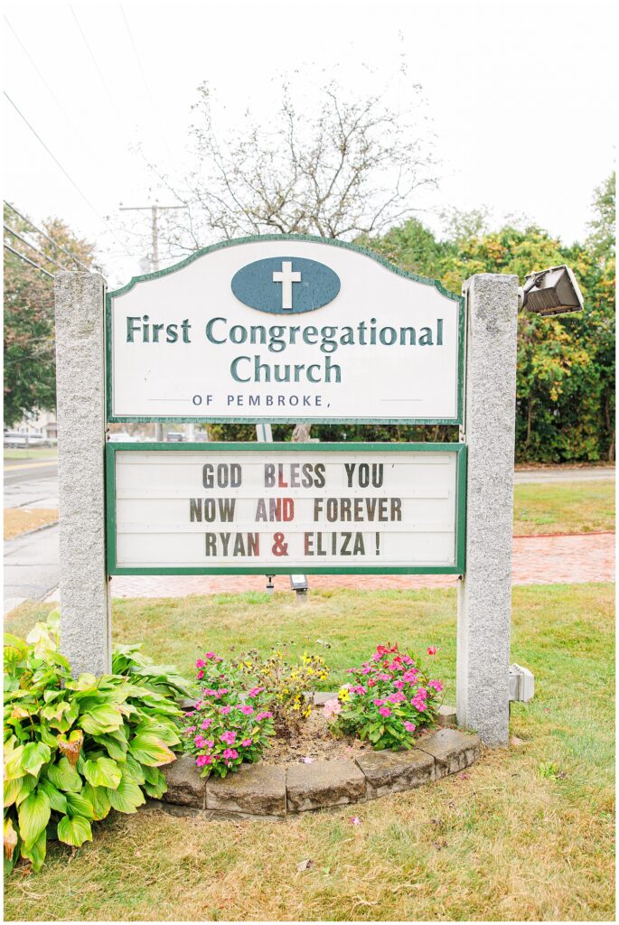 A church sign for the First Congregational Church of Pembroke. The marquee reads, “God bless you now and forever Ryan & Eliza!”