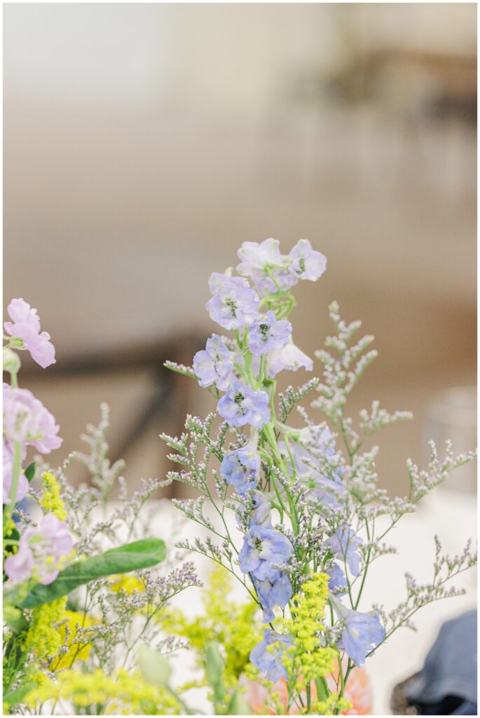 Delicate blue and yellow flower arrangement as a wedding reception centerpiece at Pembroke Pines Country Club in Pembroke, NH.