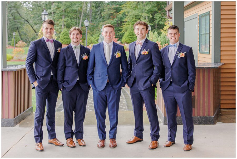 The groom and his groomsmen, all in blue suits, posing under the covered patio at Pembroke Pines Country Club in Pembroke, NH.