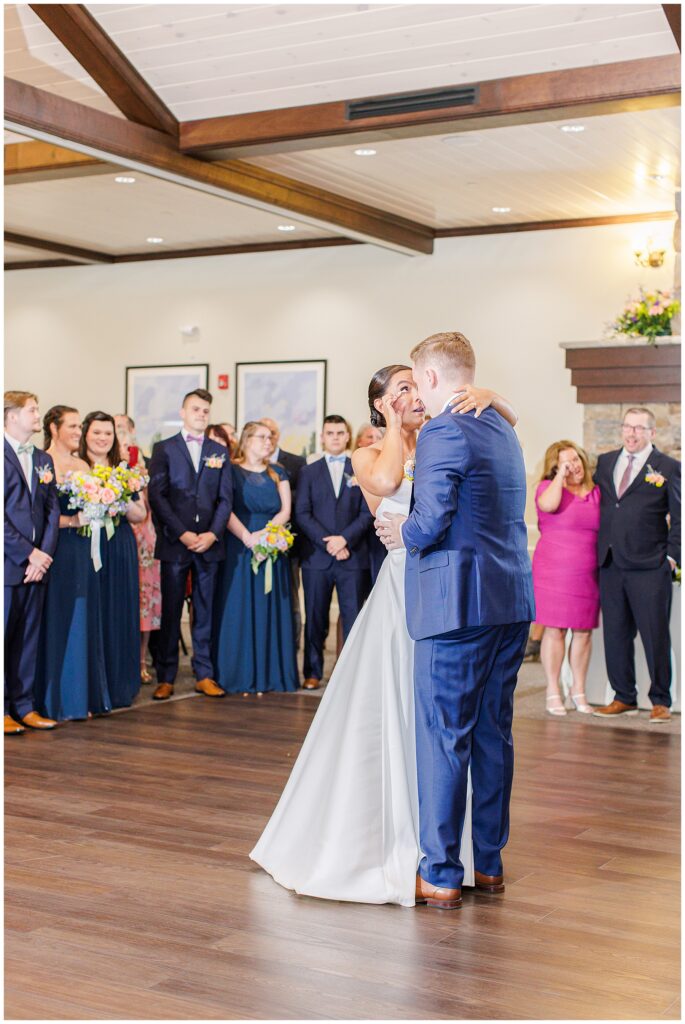 Bride and groom dancing closely during their first dance at Pembroke Pines Country Club in Pembroke, NH, surrounded by smiling guests.