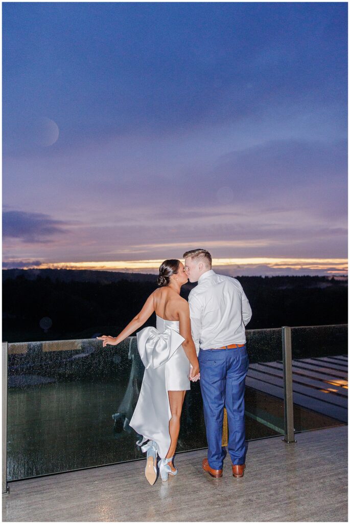 Bride and groom kissing in front of a sunset at Pembroke Pines Country Club.