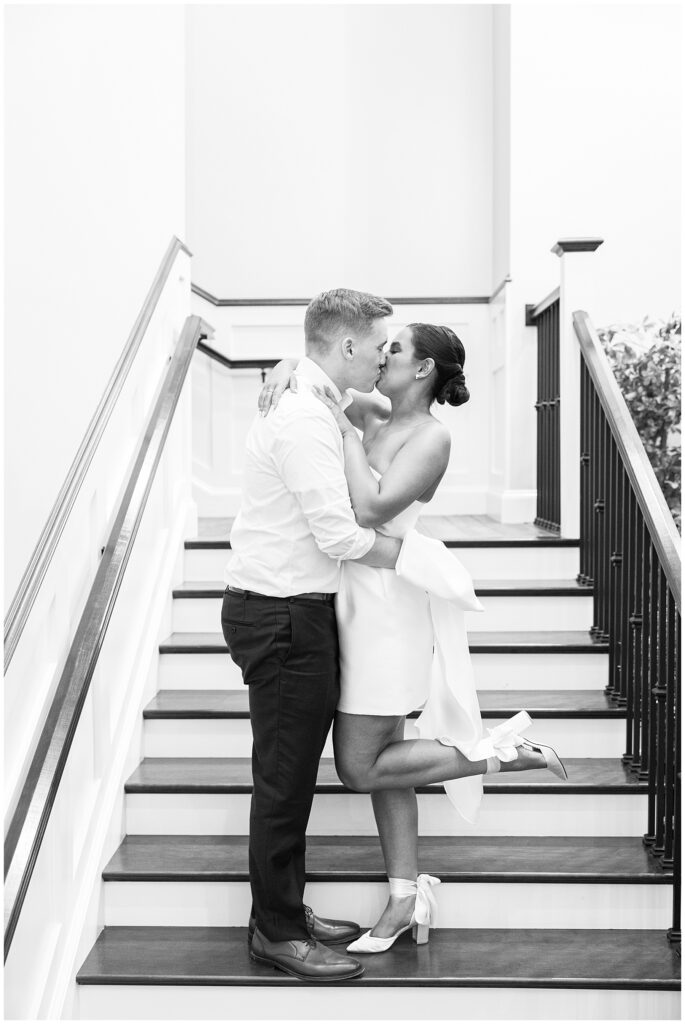 Bride and groom kissing on a stair case during their New Hampshire wedding reception at Pembroke Pines Country Club.