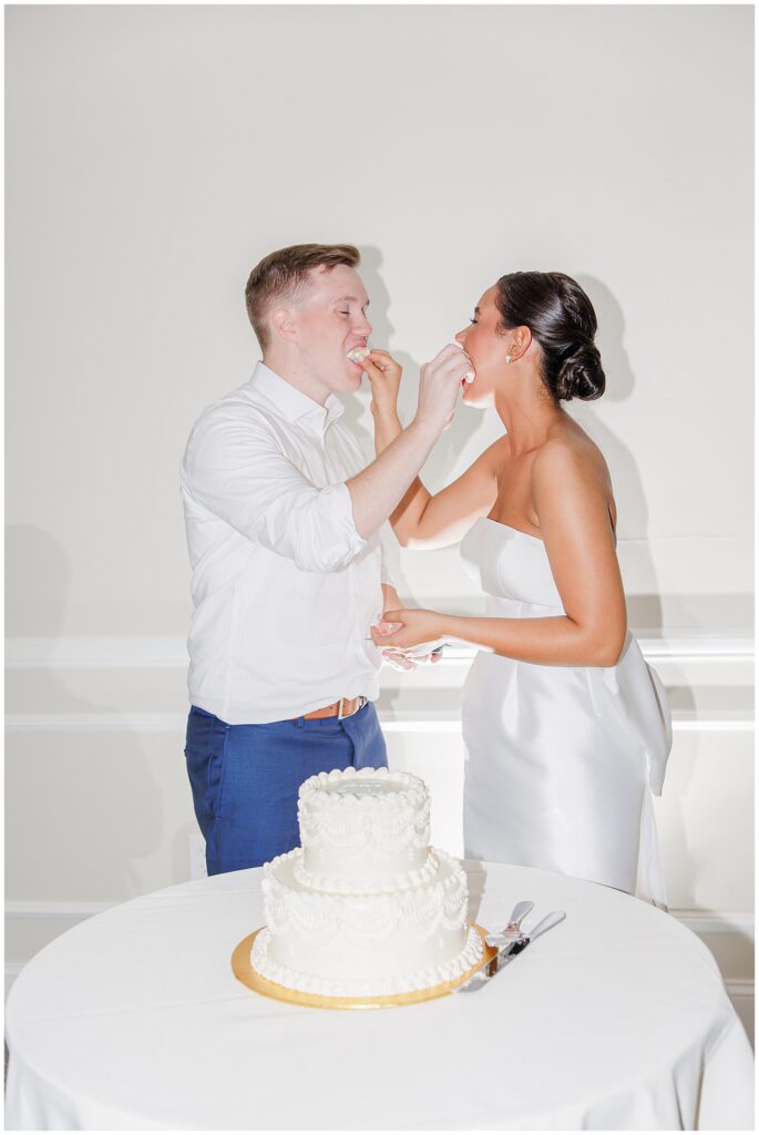  Bride and groom feeding each other their cake at there New Hamshire wedding reception