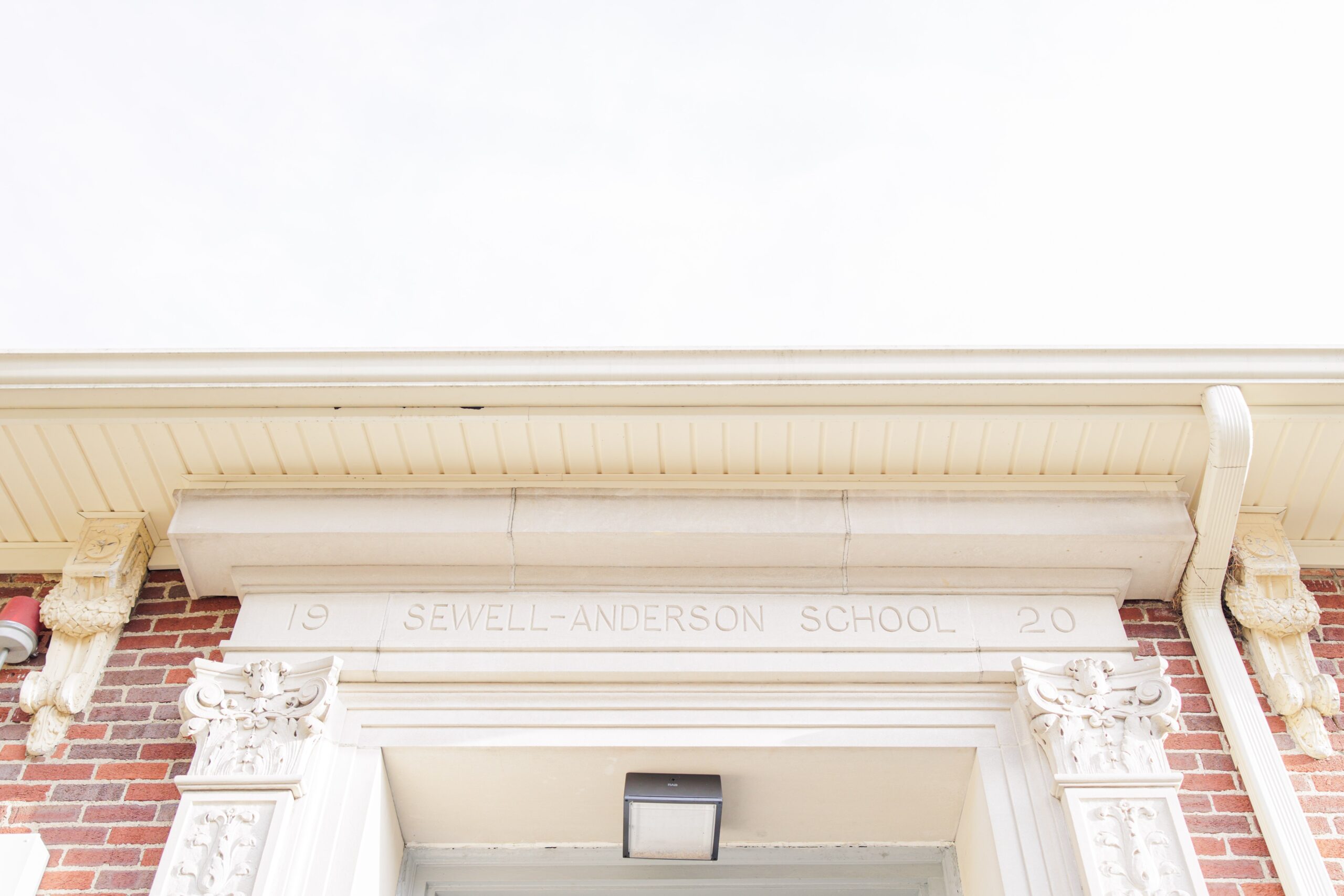 A close-up of the Sewell-Anderson School entrance, showing ornate architectural details and the building’s name engraved above the doorway, dated 1920.