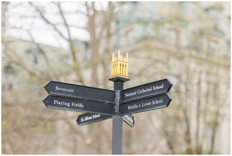 Directional sign with black arrows pointing to locations including “Beauvoir,” “National Cathedral School,” and “St. Albans School,” topped with a miniature gold cathedral, at the National Cathedral School.