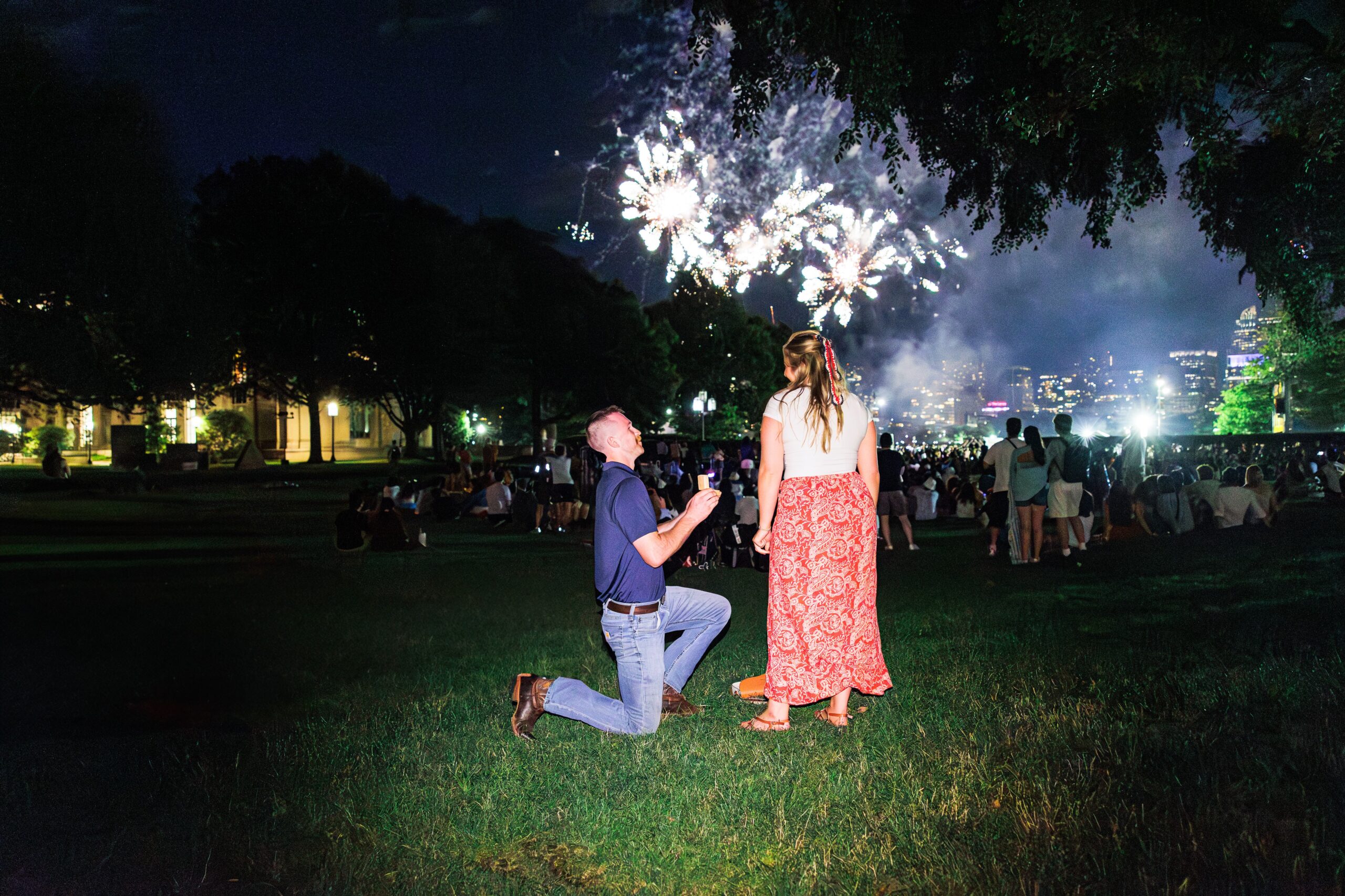 A man proposes on one knee during Boston’s 4th of July fireworks, a breathtaking moment that highlights romantic marriage proposal ideas Boston.