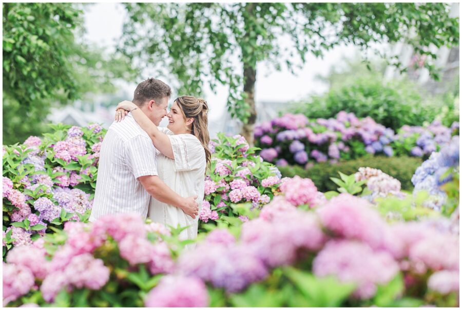 Couple embracing in a garden filled with pink and purple hydrangeas at Chatham Bars Inn