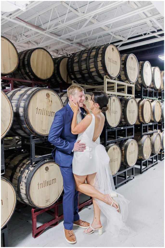 Bride and groom posing together inside a barrel room at Trillium Brewery, smiling at each other, captured by a Boston Elopement Photographer.