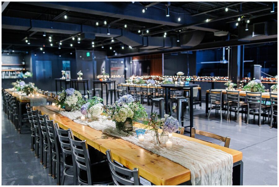 Reception tables decorated with hydrangeas, candles, and greenery inside Trillium Brewery, photographed by a Boston Elopement Photographer.
