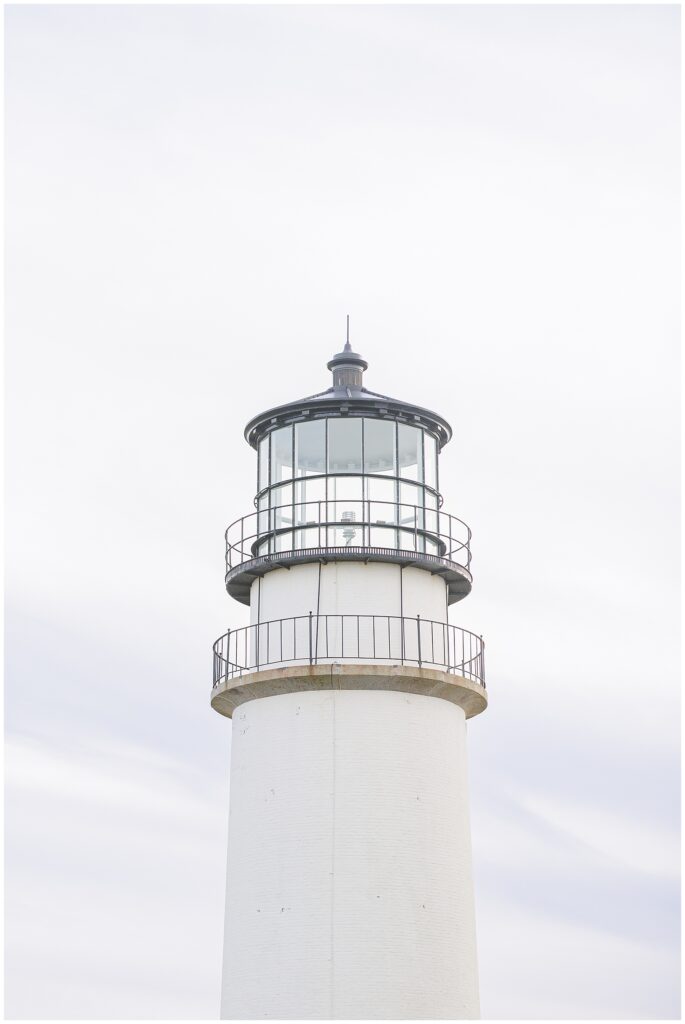 A close-up of the lantern room and top section of Highland Lighthouse against a pale sky.