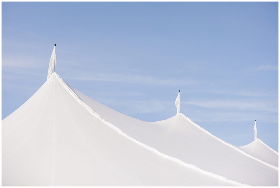 Close-up of the white peaks of a sailcloth wedding tent set against a clear blue sky at Nauset Beach Inn in Cape Cod.